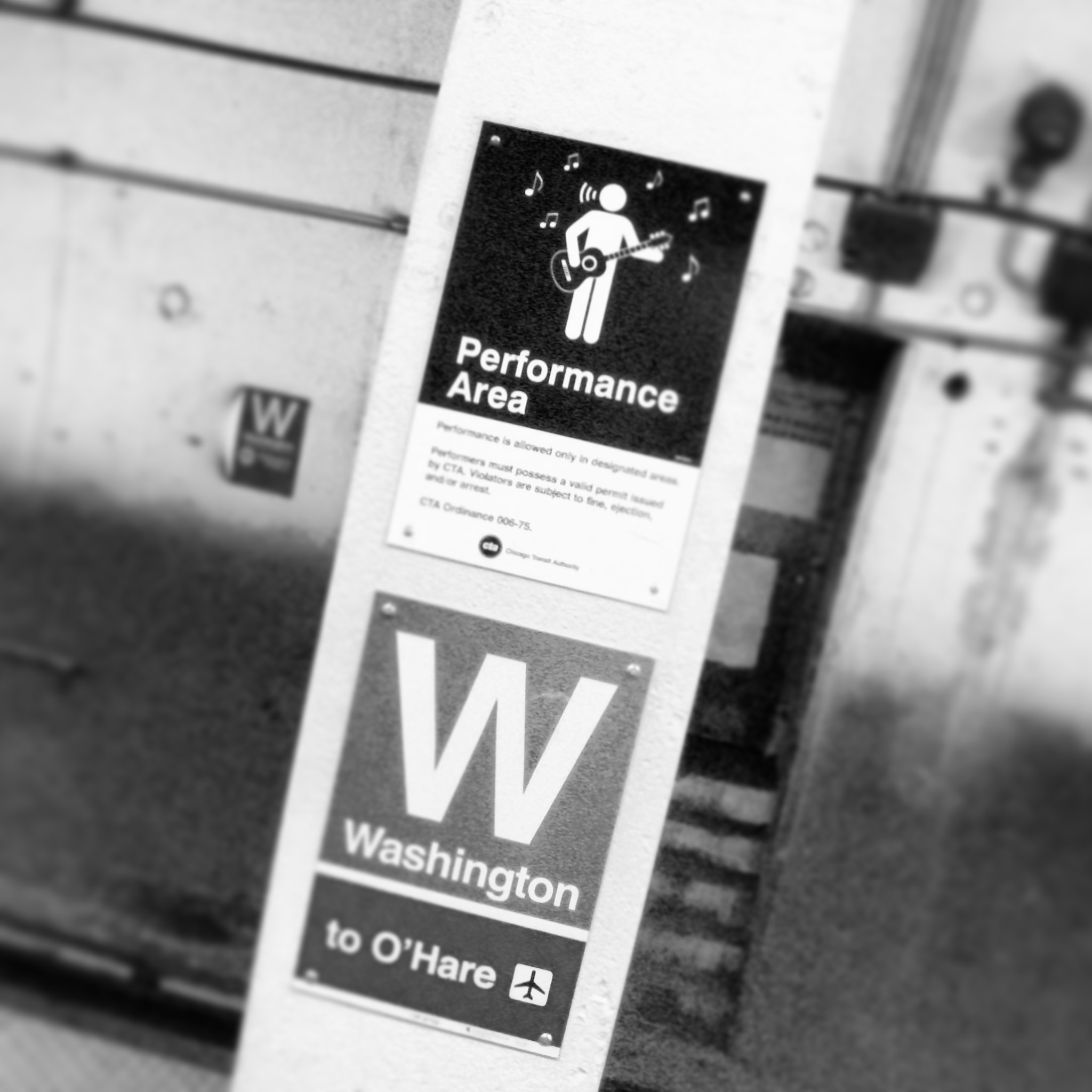 Performance area at Washington Subway Station, Chicago. Black and white photo of a post with signs