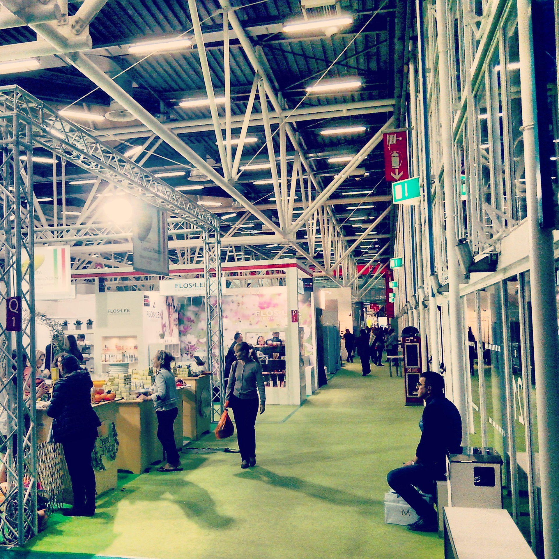 People walking along the booths inside a pavillion of Cosmoprof Beauty Show, Bologna, Italy